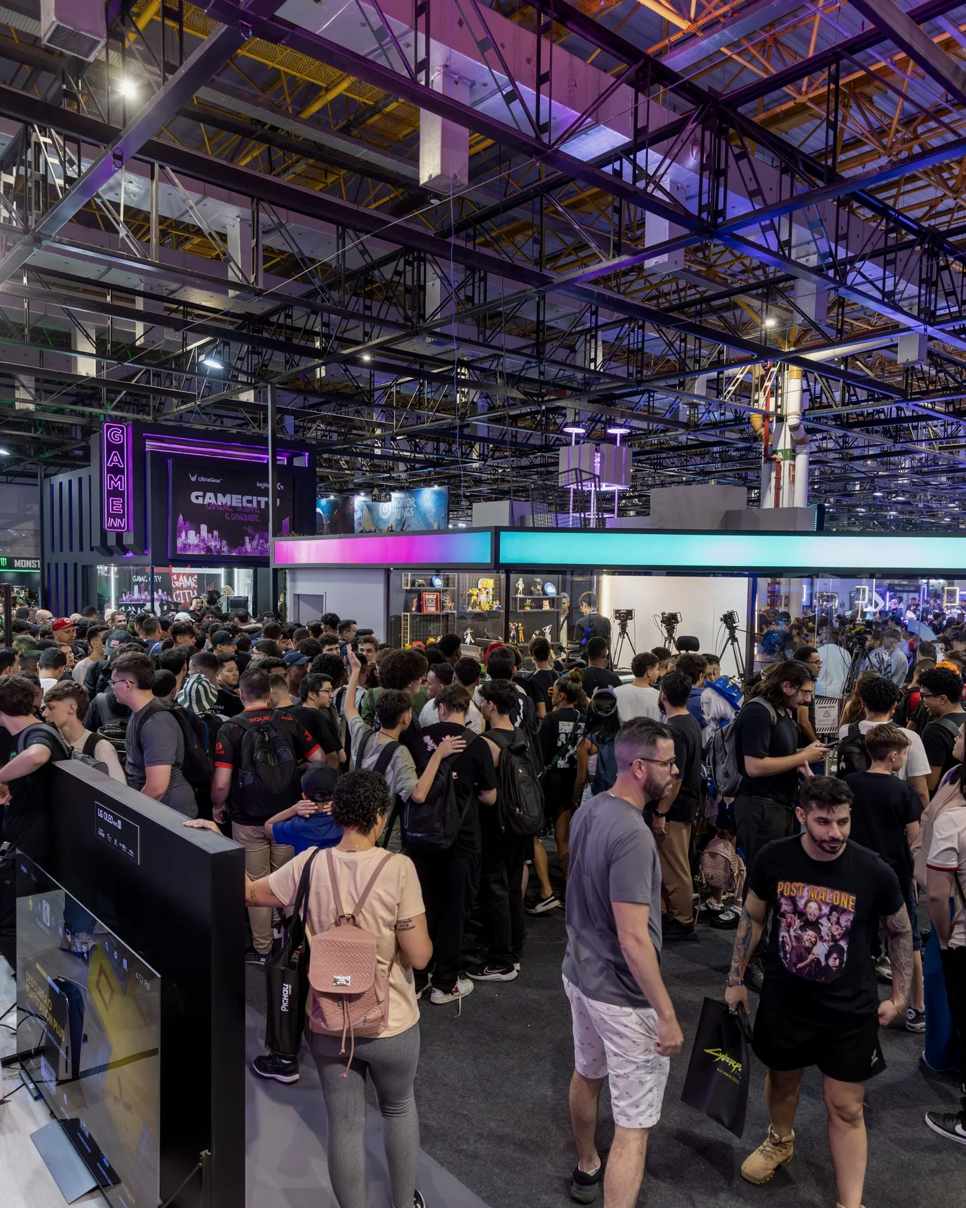 Pavilhão de feira com público, telas de LED e iluminação cênica